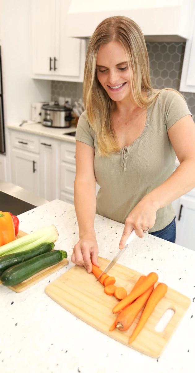Rachel cutting carrots on a kitchen cutting board